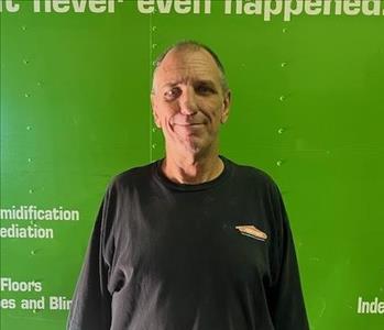 SERVPRO employee in front of green background